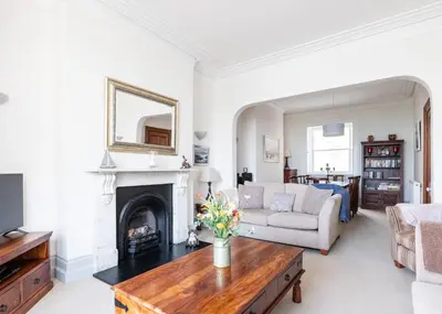 a living room with a fireplace and a couch at The Terrace 2 in Padstow