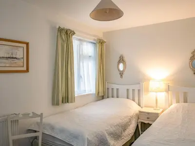a bedroom with two beds and a window at Slipway 12 in Padstow