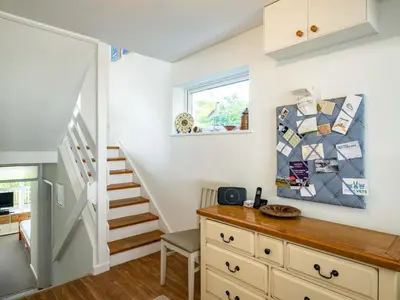 a room with a staircase and a counter with a table at Slipway 12 in Padstow