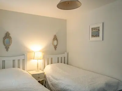 a bedroom with two beds and a lamp on a table at Slipway 12 in Padstow