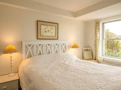 a bedroom with a white bed and a window at Slipway 12 in Padstow