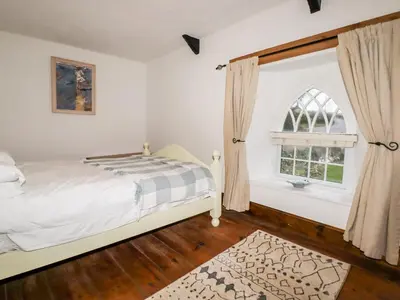 a bedroom with a bed and a window at Destiny Cottage in Boscastle