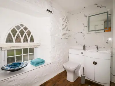 a white bathroom with a sink and a toilet at Destiny Cottage in Boscastle