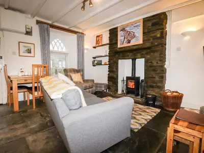 a living room with a couch and a fireplace at Destiny Cottage in Boscastle