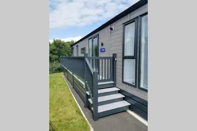 a mobile home with a staircase and windows at Lowena Lodge - Padstow in Padstow