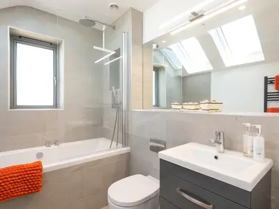 a bathroom with a sink and a toilet and a mirror at Pentire in Saint Minver