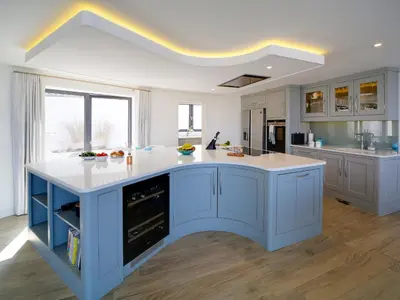 a kitchen with blue cabinets and a white counter top at Megizzy in Polzeath