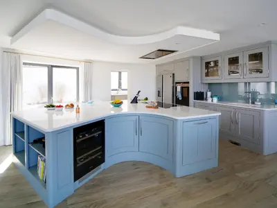 a kitchen with blue cabinets and a white counter top at Megizzy in Polzeath
