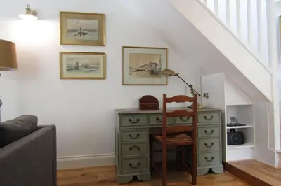 a desk with a lamp and a dresser in a room at Lovely Spacious Cottage Near The Coast in St Austell