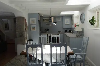 a kitchen with a table and chairs in a room at Lovely Spacious Cottage Near The Coast in St Austell