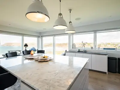 a kitchen with a large marble counter top and windows at Seascape in Polzeath