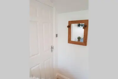 a bathroom with a mirror on the wall at St Ives apartment private parking with garden 10 minute walk into town and beach in St Ives