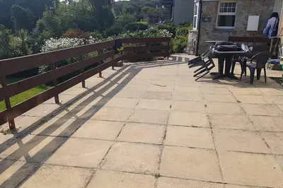 a patio with benches and a table in a yard at St Ives apartment private parking with garden 10 minute walk into town and beach in St Ives