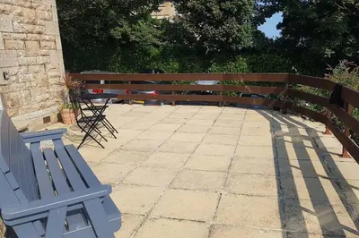 a blue bench sitting next to a wooden fence at St Ives apartment private parking with garden 10 minute walk into town and beach in St Ives