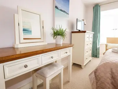 a bedroom with a dresser and a mirror at 16 Ocean Heights in Newquay