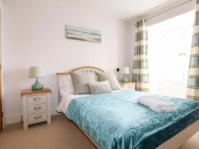 a bedroom with a bed with a blue blanket at 16 Ocean Heights in Newquay