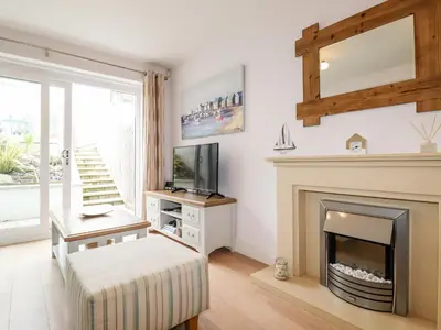 a living room with a fireplace and a tv at 16 Ocean Heights in Newquay