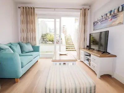 a living room with a blue couch and a tv at 16 Ocean Heights in Newquay
