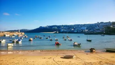 a group of boats in the water near a beach at Little Chyryn Perranuthnoe in Perranuthnoe
