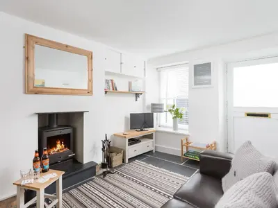 a living room with a couch and a fireplace at Cosy Cottage in Fowey