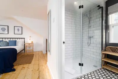 a bathroom with a shower and a bed in a room at 23 Trenwith Place in St Ives