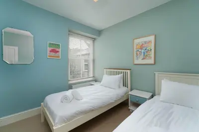 two beds in a room with blue walls at Tregarth in St Ives