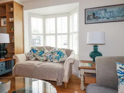a living room with a couch and a glass table at 1 Old Talbot Cottages in Lostwithiel