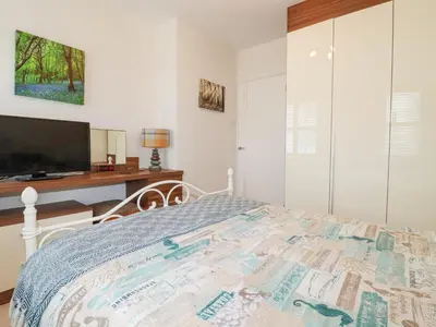 a bedroom with a bed and a desk and a television at 1 Old Talbot Cottages in Lostwithiel