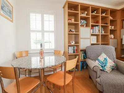 a living room with a table and chairs and a couch at 1 Old Talbot Cottages in Lostwithiel