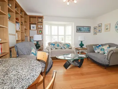 a living room with couches and a table at 1 Old Talbot Cottages in Lostwithiel