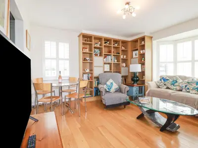 a living room with a couch and a table at 1 Old Talbot Cottages in Lostwithiel