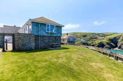 a house on the side of a grassy hill at Gulland in Port Isaac