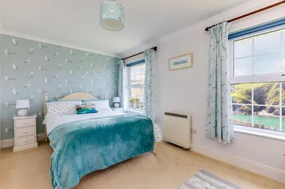 a bedroom with a bed and a window at Gulland in Port Isaac