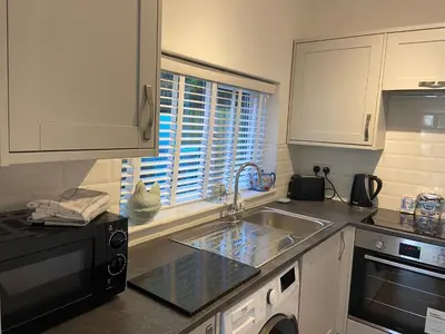 a kitchen with a sink and a microwave at Triple Deck Cottage - 2mins from Mevagissey Harbour in Mevagissey