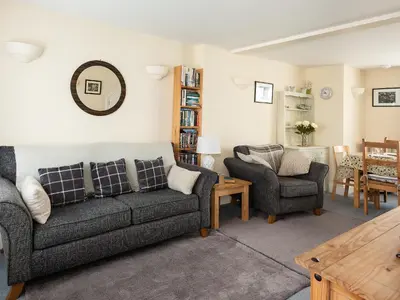 a living room with two couches and a table at Sea Glimpses in Port Isaac