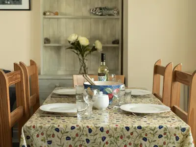 a table with plates and a bottle of wine at Sea Glimpses in Port Isaac