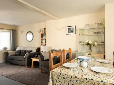 a living room with a table and a couch at Sea Glimpses in Port Isaac