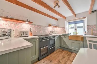 a kitchen with green cabinets and a stove top oven at Cosy Bake Cottage, Great Location in Looe, Cornwall in Looe