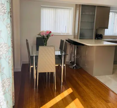 a kitchen with a table with chairs and a counter at Sunny Corner, Padstow. Spacious 3 bedrooms, 2.5 bathrooms, parking, garden. in Padstow