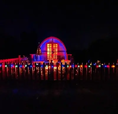 a building lit up in blue and red at night at Glamping Pod in St Austell Sleeps 2 with Spa Pool in St Austell