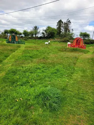 two tents in a field of green grass at Glamping Pod in St Austell Sleeps 2 with Spa Pool in St Austell