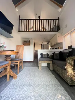 a living room with a couch and a table at The Stables - Detached Cottage with Private Garden & Hot Tub in St Austell