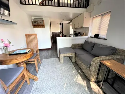 a living room with a couch and a table at The Stables - Detached Cottage with Private Garden & Hot Tub in St Austell