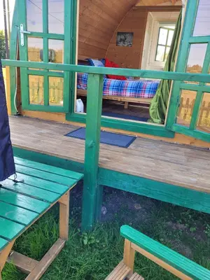 a bench on the front porch of a tiny house at Cozy Cabin Retreat in Saint Austell in Lanivet