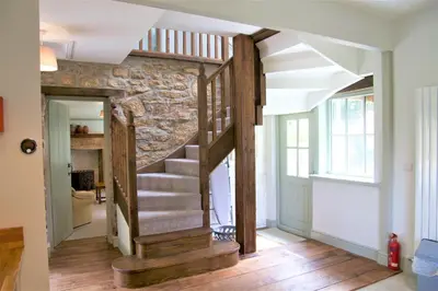 a staircase in a living room with a stone wall at Doolans in Falmouth