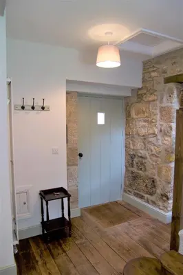 a room with a white door and a stone wall at Doolans in Falmouth