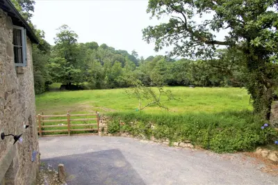 a driveway leading to a field with a fence at Doolans in Falmouth