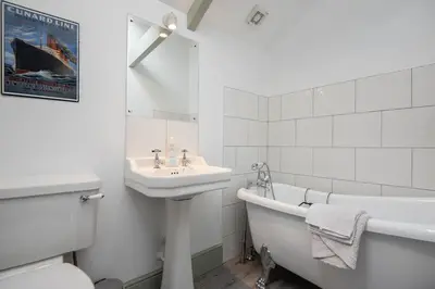 a bathroom with a sink and a tub and a bath tub at Doolans in Falmouth