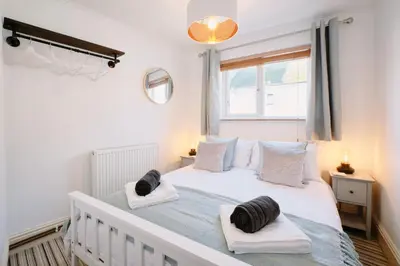 a bedroom with a white bed with two towels on it at Finest Retreats - Scallop Cottage in Porthleven