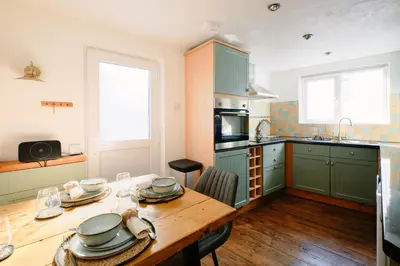 a kitchen with a wooden table with dishes on it at Finest Retreats - Scallop Cottage in Porthleven